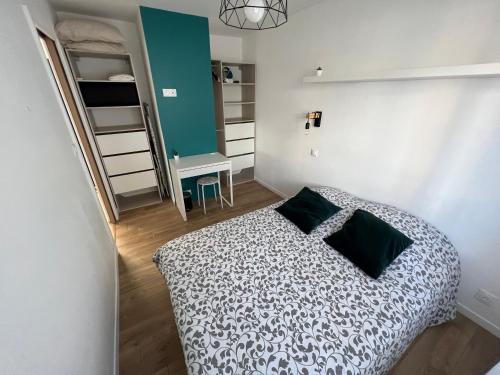 Un dormitorio pequeño con una cama y un escritorio. en Appartement 2 chambres en bord de mer 46m2, en Sète