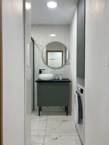 een badkamer met een wastafel en een spiegel bij Appartement 2 chambres en bord de mer 46m2 in Sète