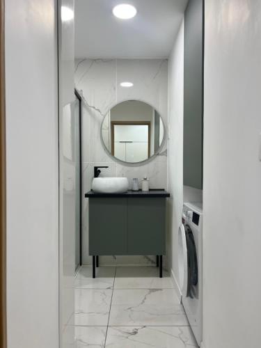 un baño con lavabo y espejo en Appartement 2 chambres en bord de mer 46m2, en Sète