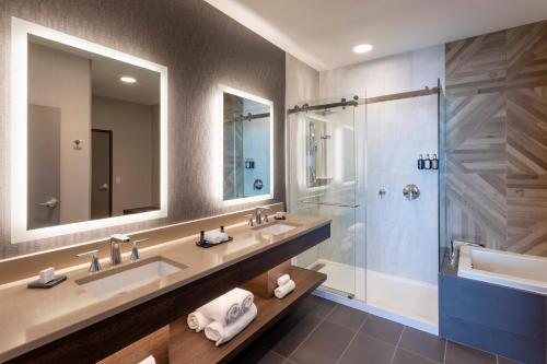 a bathroom with two sinks and a shower at Running Aces Hotel & Casino, Trademark Collection by Wyndham in Forest Lake