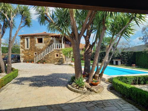 a house with palm trees and a swimming pool at Casa da Tia Palmira in Castelo de Paiva