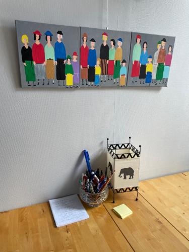 un bureau avec une peinture de personnes sur un mur dans l'établissement Libertécool, à La Meignanne