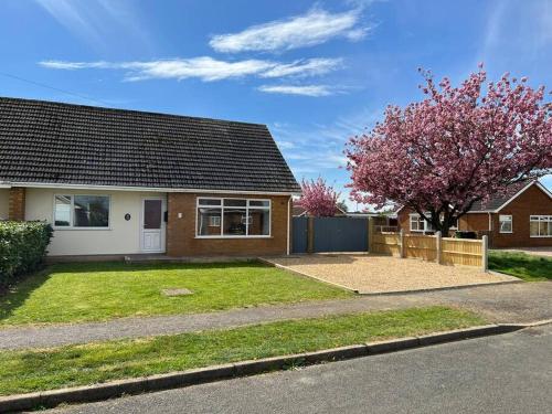 a house with a large yard in front of it at Modern Coastal 2 Bedroom Home to Relax and Unwind in Heacham