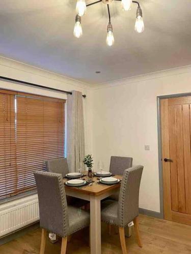 a dining room with a table and chairs and a window at Modern Coastal 2 Bedroom Home to Relax and Unwind in Heacham
