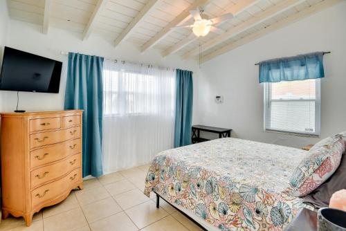 a bedroom with a bed and a dresser and a tv at Ormond Beach Vacation Rental - Walk to Ocean! in Ormond Beach