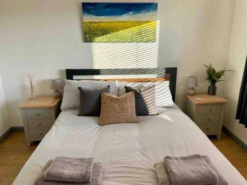 a bedroom with a large bed with two night stands at Modern Coastal 2 Bedroom Home to Relax and Unwind in Heacham