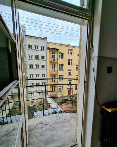 Big and cozy bedroom in Krakow في كراكوف: نافذة مفتوحة مطلة على مبنى