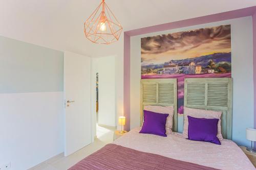 Dormitorio con cama morada y pintura en la pared en VILLA - SPA JACUZZI - TERRASSES - CLIM & BBQ - La Valette-du-Var en La Valette-du-Var