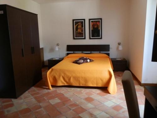 1 dormitorio con 1 cama con manta naranja en Agriturismo Ai Monaci en Montano Antilia