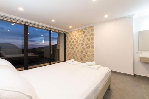 a bedroom with a large white bed and a large window at Luxurios Private Summerhouse by Renovu in Kalkan