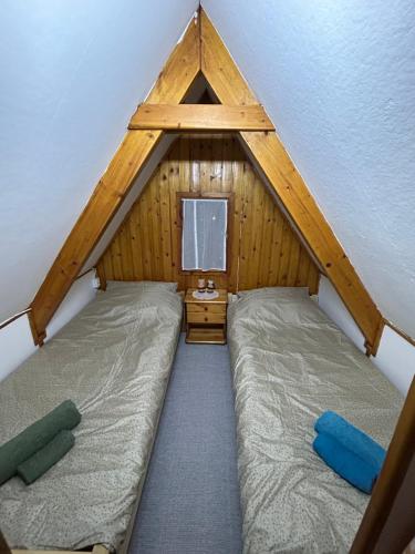 a bedroom with two beds in a roof at Aqua Faház in Mesteri