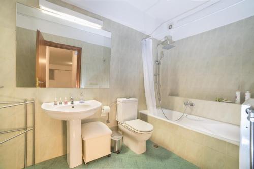 een badkamer met een wastafel, een toilet en een ligbad bij Spacious Modern Apartments With Great Rooftop View in Athene
