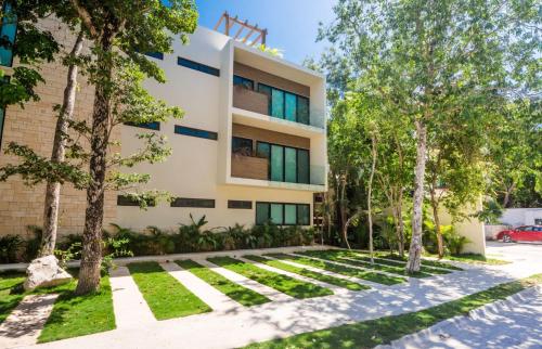 a building with trees in front of it at Sweet Tulum 202 in Tulum