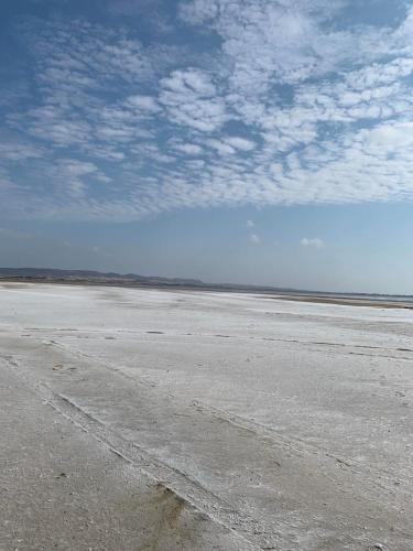an empty beach with a blue sky and clouds at Jimmy's Crib in Moudhros