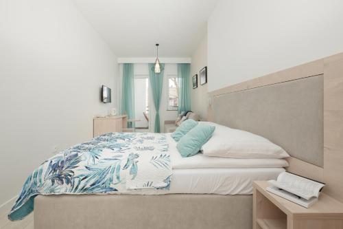 a bedroom with a large bed with blue and white sheets at Apartament LENA Dziwnówek nad morzem in Dziwnówek