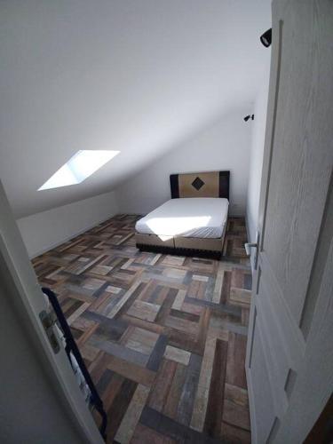 Cette chambre mansardée dispose d'un lit et de parquet. dans l'établissement Appartement Les 3 L, à Vions