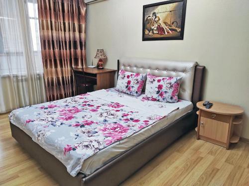 a bedroom with a bed with pink flowers on it at Квартира на Пентагоне in Bender