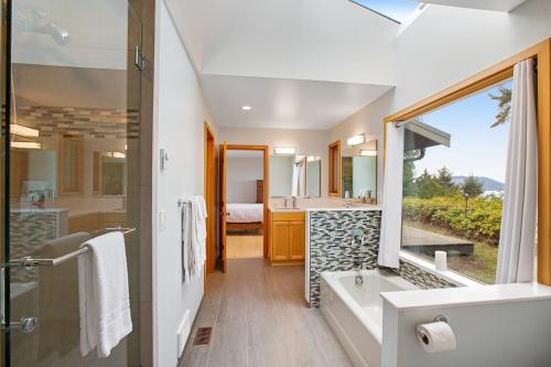 ein Bad mit einer Badewanne, einem Waschbecken und einer Dusche in der Unterkunft Blufftop on Freshwater Bay in Port Angeles
