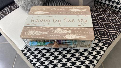 a box on a table with a happy by the sea sign at LA DOLCE VITA MAZET A GASSIN GOLFE DE SAINT TROPEZ in Gassin