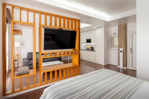 een slaapkamer met een televisie in een houten entertainmentcentrum bij El Sol,10 in La Laguna
