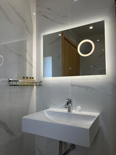 a bathroom with a white sink and a mirror at Hotel Mare in Lignano Sabbiadoro
