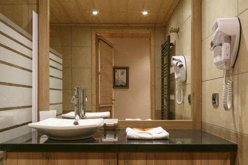 a bathroom with a sink and a mirror at CGH Résidences & Spas Le Napoléon in Montgenèvre