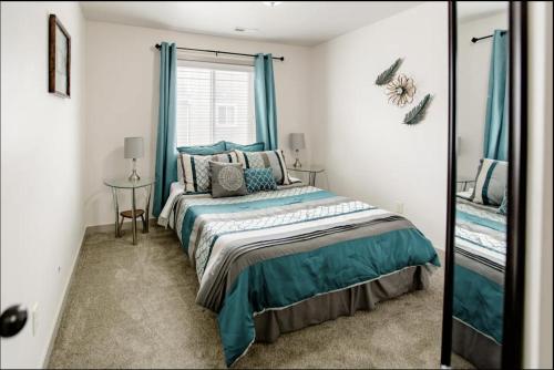 a bedroom with a bed with blue curtains and a mirror at Family-friendly Suite with HotTub MemoryBeds SmartTV in Vineyard