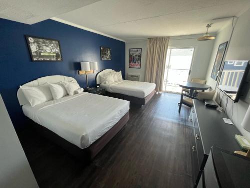 a hotel room with two beds and a television at Hotel Dewey in Dewey Beach