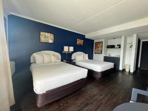 een slaapkamer met 2 bedden en een blauwe muur bij Hotel Dewey in Dewey Beach