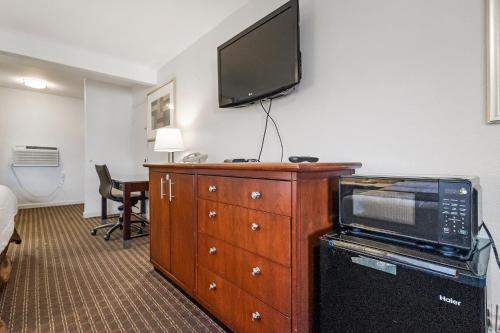 una camera d'albergo con TV sopra un comò di Heritage Inn Express Hayward a Hayward