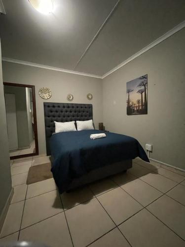 a bedroom with a bed with a blue blanket at Yello guest house in Vanderbijlpark