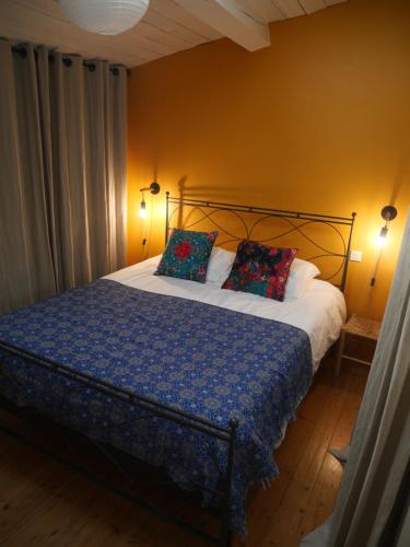 1 cama con 2 almohadas en una habitación en Chambre et salon climatisés chez l'habitant dans une maison de village de charme, en Passa