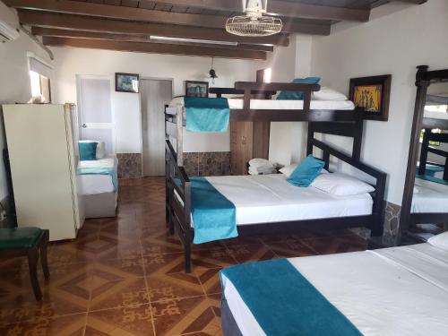 Hospedaje Villa Naloy في سانتا مارتا: غرفة مع ثلاثة أسرة بطابقين في غرفة