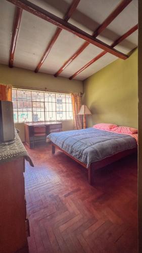 ein Schlafzimmer mit einem Bett und einem Schreibtisch in einem Zimmer in der Unterkunft Casa Carhuaz in Carhuaz