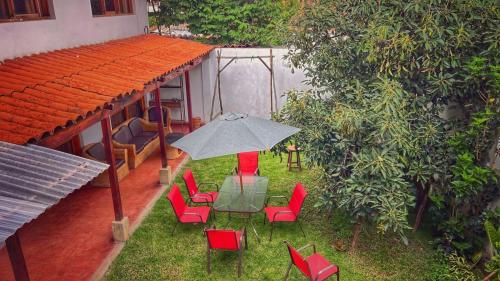 un patio con mesa, sillas y sombrilla en Casa Carhuaz, en Carhuaz