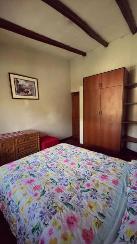 1 dormitorio con 1 cama grande con colcha de flores en Casa Carhuaz, en Carhuaz