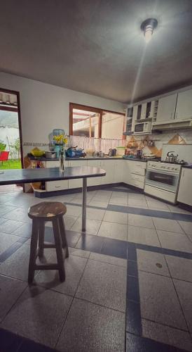 eine Küche mit einem Tisch und einem Hocker darin in der Unterkunft Casa Carhuaz in Carhuaz