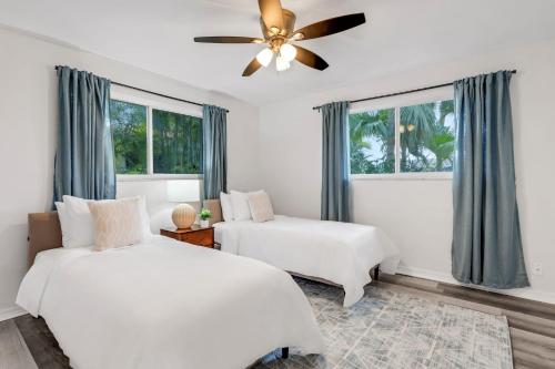 Kasa Mariposa Fort Lauderdale في فورت لاودردال: غرفة نوم بسريرين ومروحة سقف