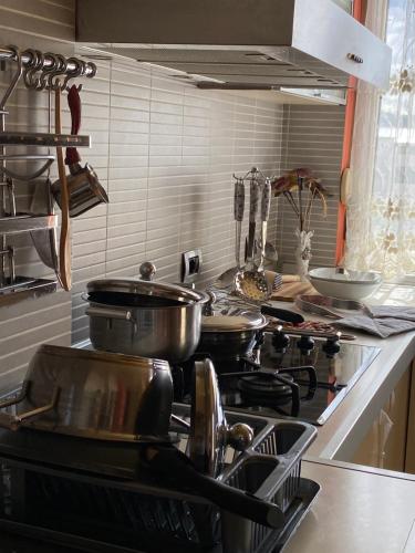 uma cozinha com panelas e frigideiras no fogão em Sunshine Place em Elbasan