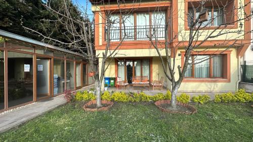 two trees in a yard in front of a building at Doğa Villa Guest House in Buyukcekmece