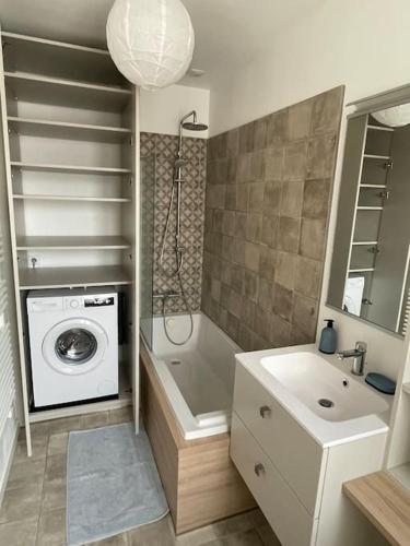 une salle de bain avec une machine à laver et un lavabo dans l'établissement Le Belvédère, à Wimereux