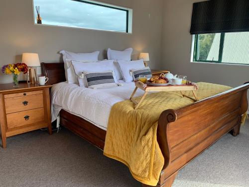 a bedroom with a bed with a tray of food on it at Ridley Manor in Ohakune