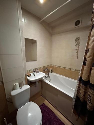 a bathroom with a toilet and a sink and a tub at Apartment near train station and close to city center in Kyiv
