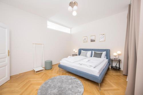 a white bedroom with a bed and a rug at Luxury Suites Liechtenstein in Vienna