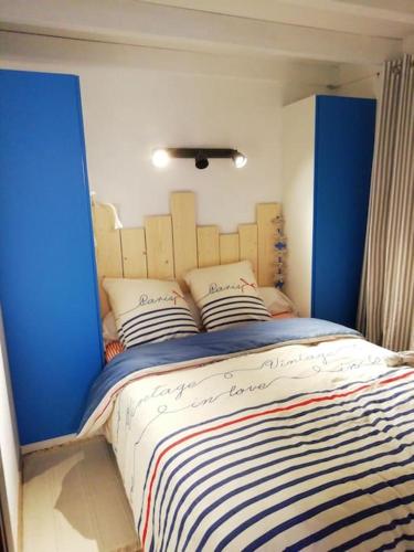 - une chambre avec un lit bleu et blanc et des oreillers dans l'établissement Joli appart. entre Biarritz et Bordeaux à Moliets, à Moliets-et-Maa