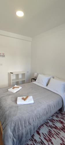 a large bed with two towels on top of it at Habtiar Guest House in Braga