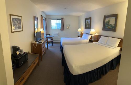 a hotel room with two beds and a television at Wessex Inn By The Sea in Cowichan Bay