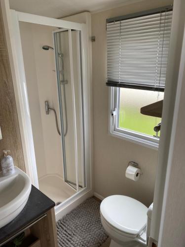 a bathroom with a shower and a toilet and a sink at Yogi's Space in Birchington
