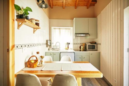 una pequeña cocina con mesa de madera y sillas en Casa Montse. Apartamentos turísticos, en Ribadeo