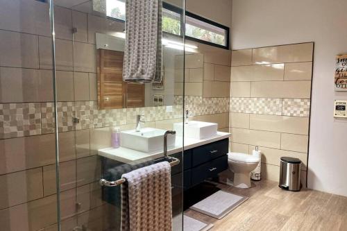 a bathroom with a sink and a toilet at An abundance of wildlife at Jungle Glory Home Abajo in Manuel Antonio